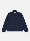 The Navy Linen Slub Weave E130 Jacket is shown laid flat against a solid white background. The jacket features a classic collar, a full-button front, and two large patch pockets at the waist. The textured slub weave of the navy linen-cotton fabric is visible throughout the garment.