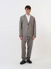 The Mid Grey Linen Slub Weave Two Button Jacket is shown laid flat against a plain white background. The image highlights the jacket's textured slub weave, two-button front, wide lapels, and three front patch pockets.