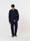 The Navy Linen Slub Weave Bakers Jacket is shown laid flat against a solid white background. The garment features a classic pointed collar, a five-button front, and three prominent patch pockets on the front, including one on the chest. The navy blue fabric has a visible slub weave texture.