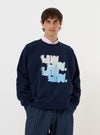A model is wearing the Navy Brush Back Sweat FM Raglan Sweatshirt against a plain white background. The image features a front view of the navy blue sweatshirt, highlighting the raglan sleeve construction, a classic crew neckline, and ribbed detailing at the cuffs and hem.