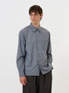 A model is wearing the Pale Blue Check Plaid Lazy Day Shirt against a plain white background. The shirt features a pale blue and white plaid pattern, a button-down front, and a classic collar. The model is wearing the shirt tucked out, paired with dark trousers. The focus is on the upper half of the garment and the fit on the model.