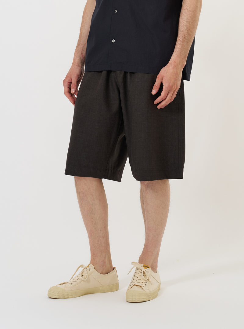 A male model is wearing the Brown Marl Tropical Suiting Vacation Short against a plain white background. The shorts feature a relaxed fit and reach mid-thigh, paired with dark socks and black shoes. The model is shown from the waist down in a front-facing standing pose.
