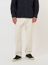 A model is wearing the Ecru Slub Drill Dizzy Trouser against a plain white background. The image shows the trousers from the waist down, highlighting the loose, wide-leg fit and the textured ecru cotton fabric. The model is standing straight and wearing dark shoes. No mannequin is present in the image.