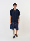 The Navy Linen Cotton Shirting Camp Shirt is displayed flat against a plain white background. The shirt features a camp collar, a button-down front with tonal buttons, short sleeves, and a single chest pocket on the left side. The fabric is a solid navy blue linen-cotton blend.