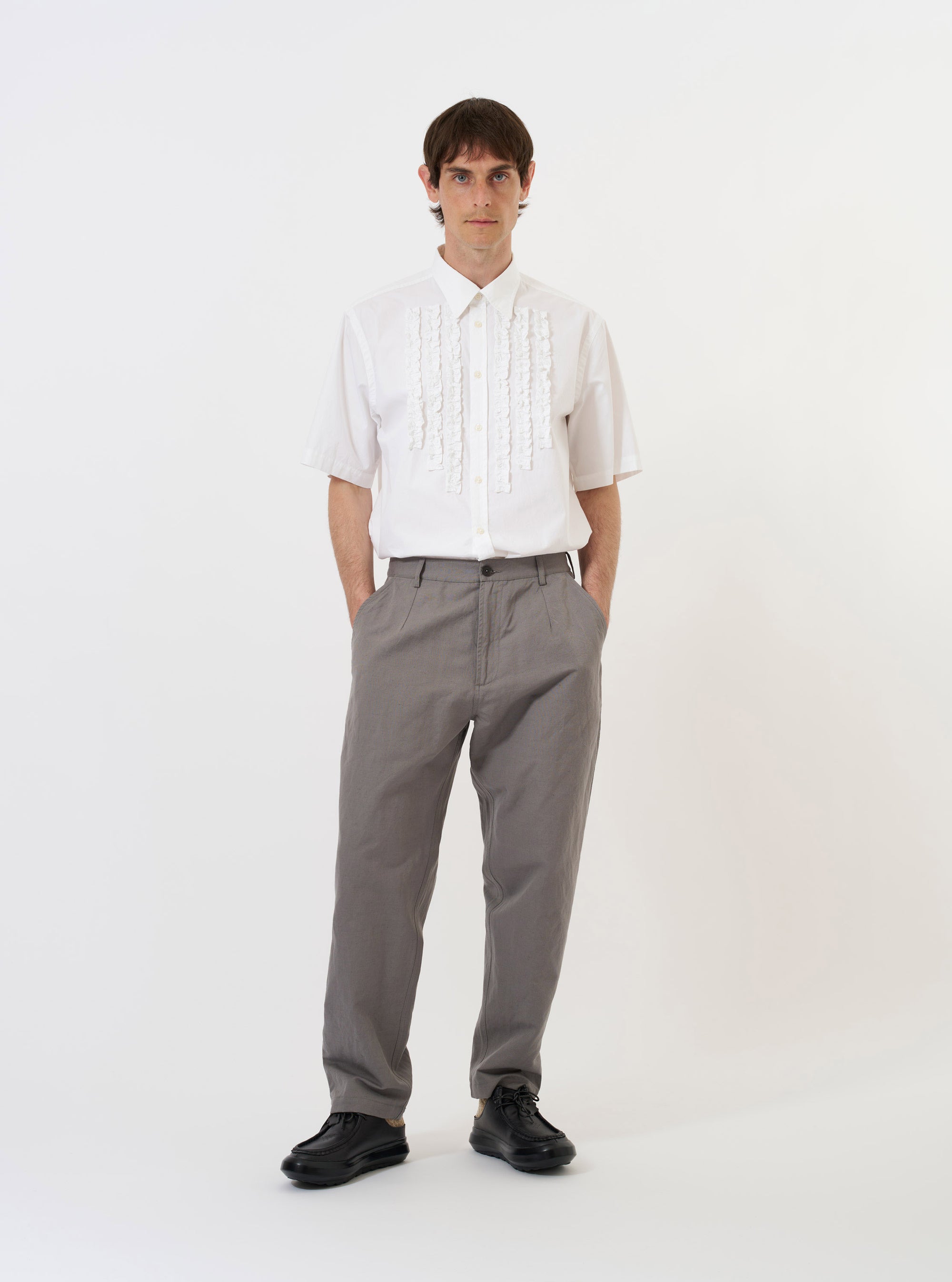 The White Poplin Frill Shirt is shown laid flat against a plain white background. The shirt features a crisp white poplin fabric, a standard collar with frill edging, a full button-down front, and long sleeves.