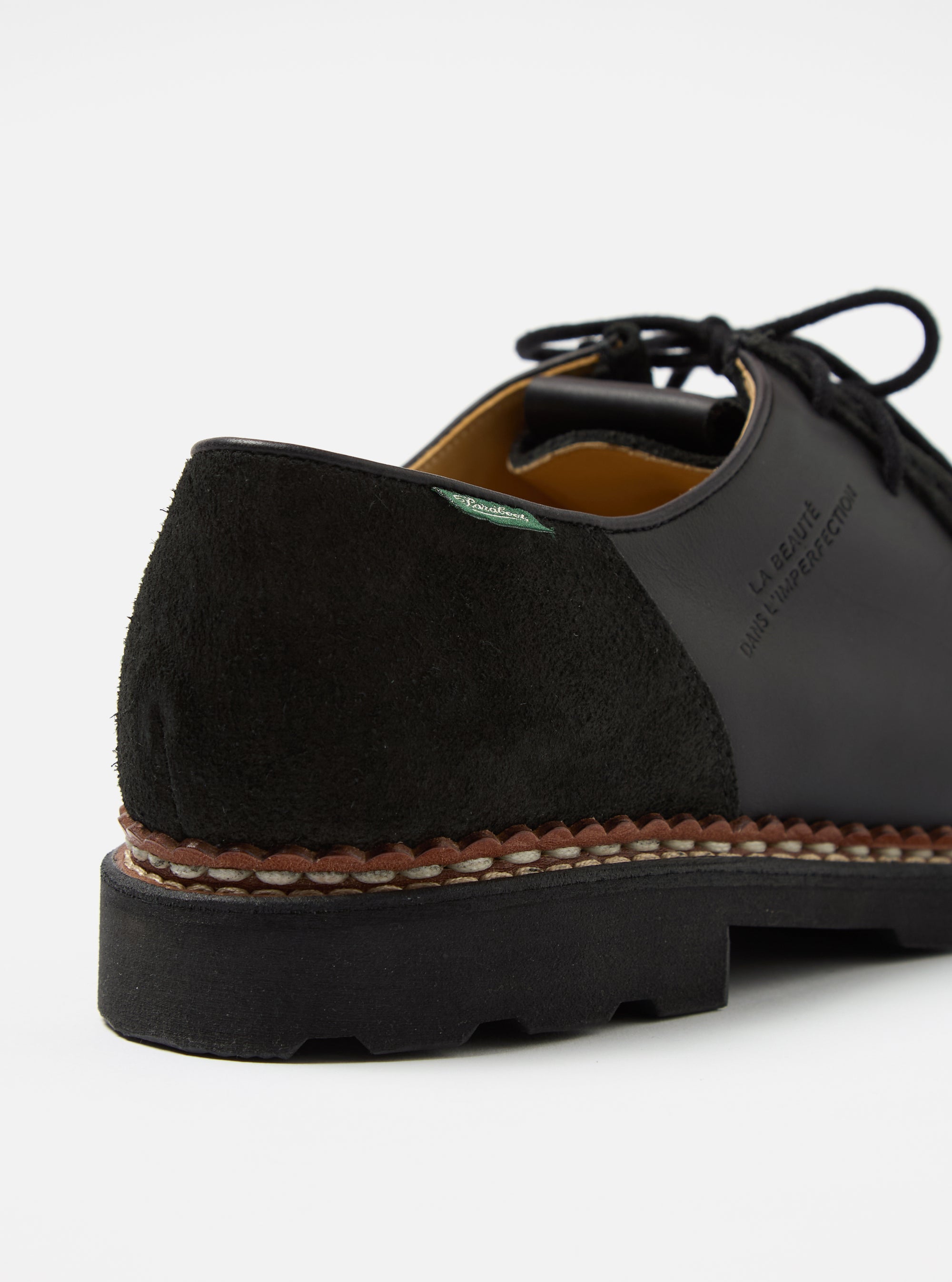 Close-up of the Paraboot x Universal Works Michael in Black Leather/Suede. The shoe features black leather and suede, with a welted sole. Shot on a white background.
