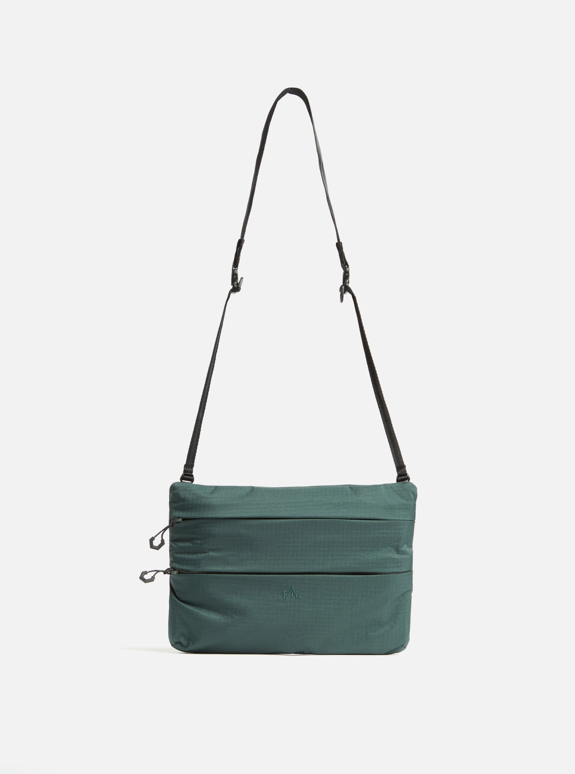 The F/CE.® Green Nylon 2.5 Layer Sacoche, a green nylon bag with a black strap, is centered on a white background. The bag has a rectangular shape with horizontal stitched lines.