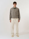 A model wears the Multi Lucas Cotton Mix E130 Jacket over a light-colored shirt and dark trousers, standing against a plain white background. The jacket features a bold, multi-colored check pattern in shades of blue, brown, and cream. It is designed with a classic collar, a two-way front zip closure, and two large flap pockets at the waist. The model is shown from a front angle, highlighting the garment's relaxed, boxy fit.