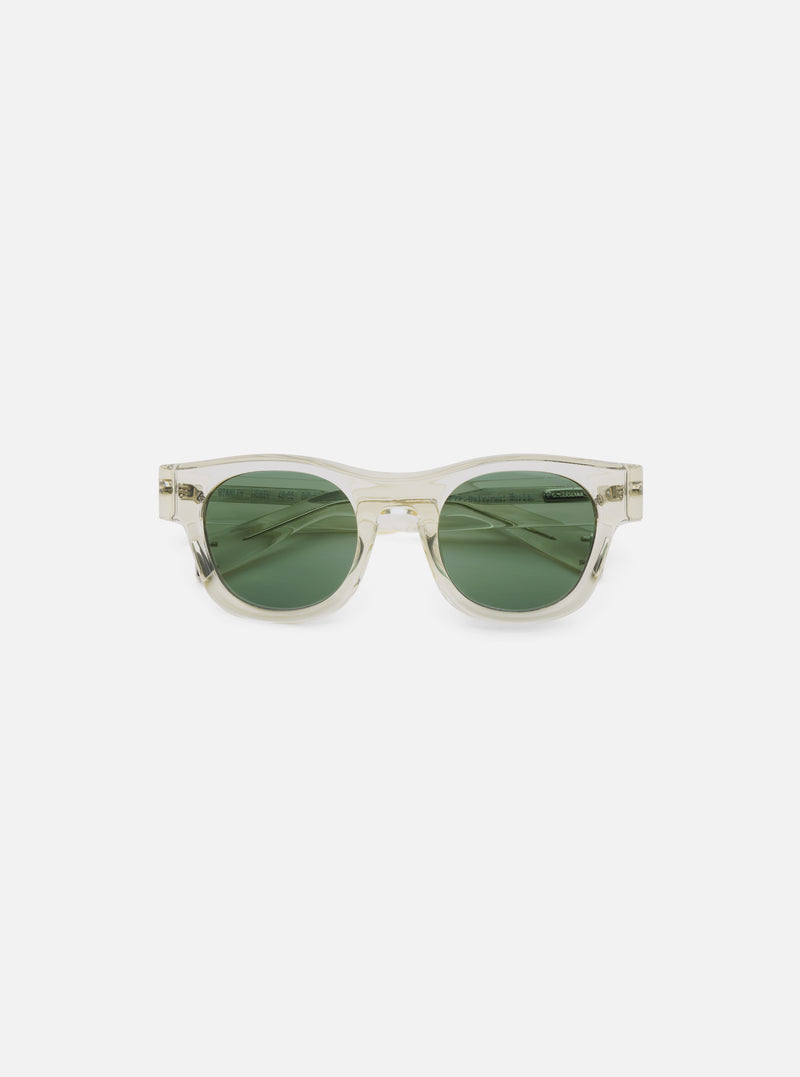 Close-up of A. SOCIETY x Universal Works Honey Stanley Sunglasses. Clear frame, green lenses. Shot on a clean white background.
