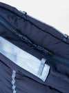 Close-up of the Topologie x Universal Works Insignia Blue UW Tech Helmet Bag. Shows the bag's blue fabric, zipper, and light blue straps against a white backdrop.