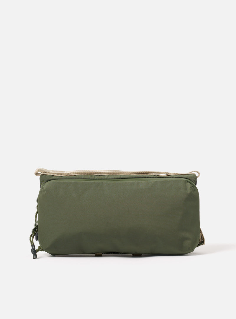 The Topologie x Universal Works Rifle Green UW Tech Bottle Sacoche Medium on a white background. The sacoche is rifle green with beige straps and drawstrings.
