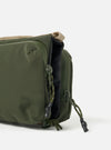 Close-up of the Topologie x Universal Works Rifle Green UW Tech Bottle Sacoche Medium on a white background. Shows the green material, beige strap, and zipper pulls.