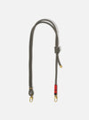The Topologie x Universal Works Red Hitch UW Rope 8mm Rope Strap on a white background. The strap is gray and brown with gold hardware and a red accent.