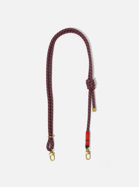 Topologie x Universal Works Olive Hitch UW Rope 8mm Strap on a white background. The rope is red and navy with gold hardware.