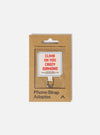Topologie x Universal Works Off White UW Tech Phone Strap Adapter in its brown cardboard packaging. The adapter has a white fabric with "Climb on you crazy diamond" printed on it.