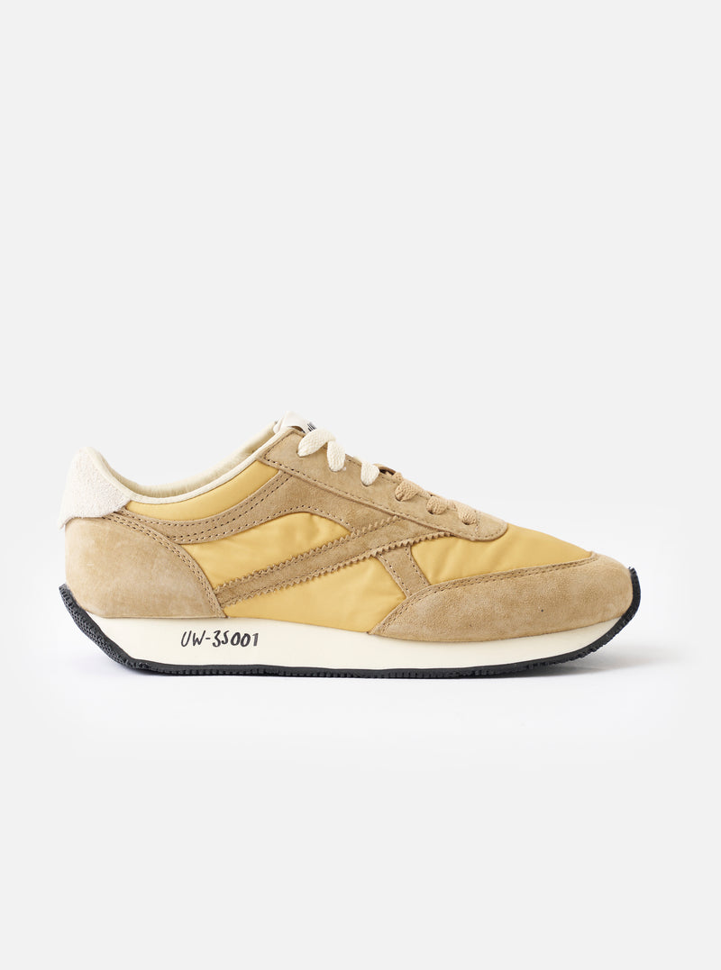 A side profile view of the Walsh x Universal Works Tornado sneaker in Beige Leather/Canvas on a plain white background, highlighting the layered beige suede overlays, canvas panels, and cushioned foam midsole.