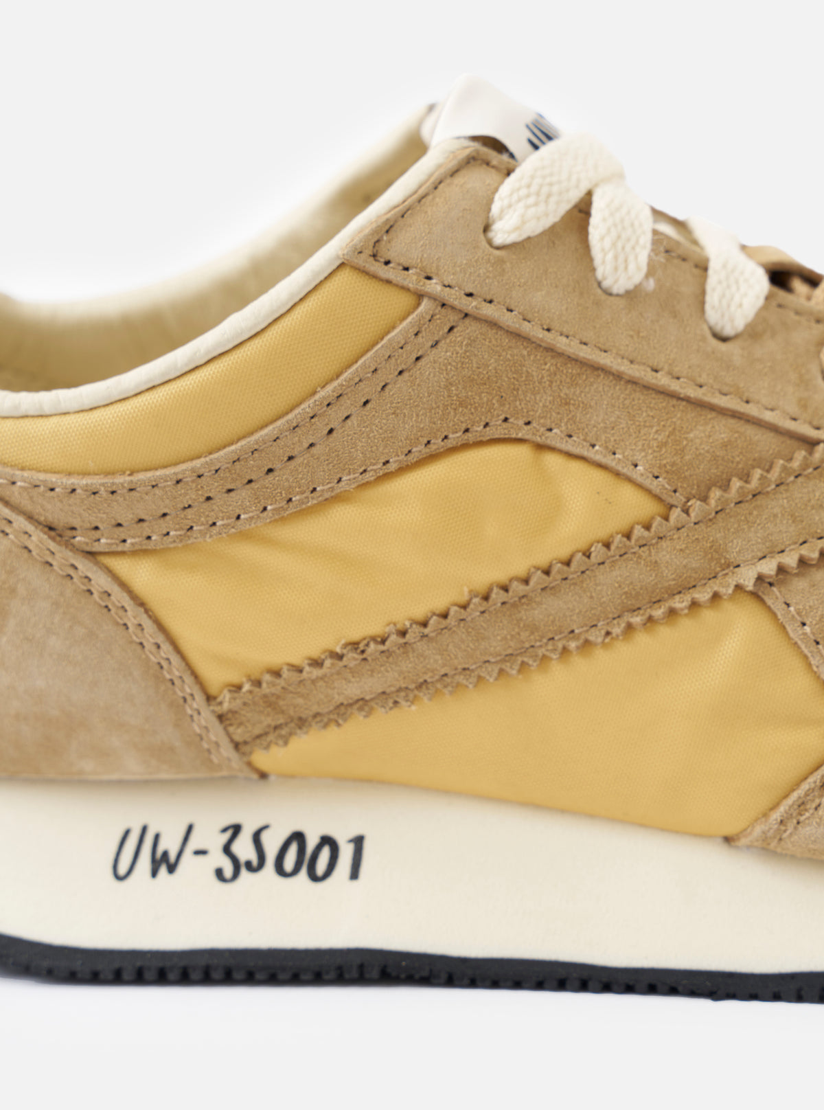 A rear view of the Walsh x Universal Works Tornado sneaker in Beige Leather/Canvas on a plain white background, displaying the heel counter construction, collar padding, and layered rubber outsole profile.