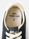 A bottom view showing the rubber tread sole of the Walsh x Universal Works Tornado in Black Leather/Canvas against a white background, emphasizing the deep traction pattern and sole grip.