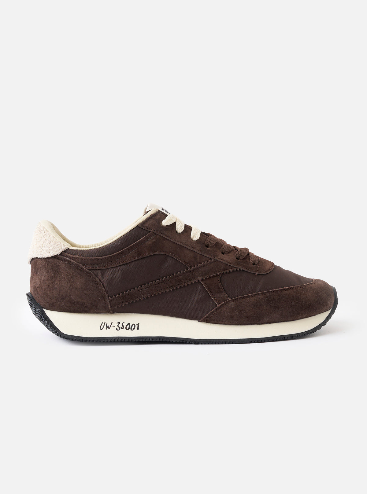 A side profile view of the Walsh x Universal Works Tornado sneaker in brown leather and canvas set against a clean white background, showcasing the suede panelling, layered upper construction, white midsole, and Vibram lugged outer sole.