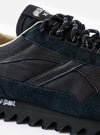 A top-down view of the Walsh x Universal Works Ensign in Black Leather/Canvas on a plain white background, featuring the black laces, branded inner soles, and rounded toe box silhouette.