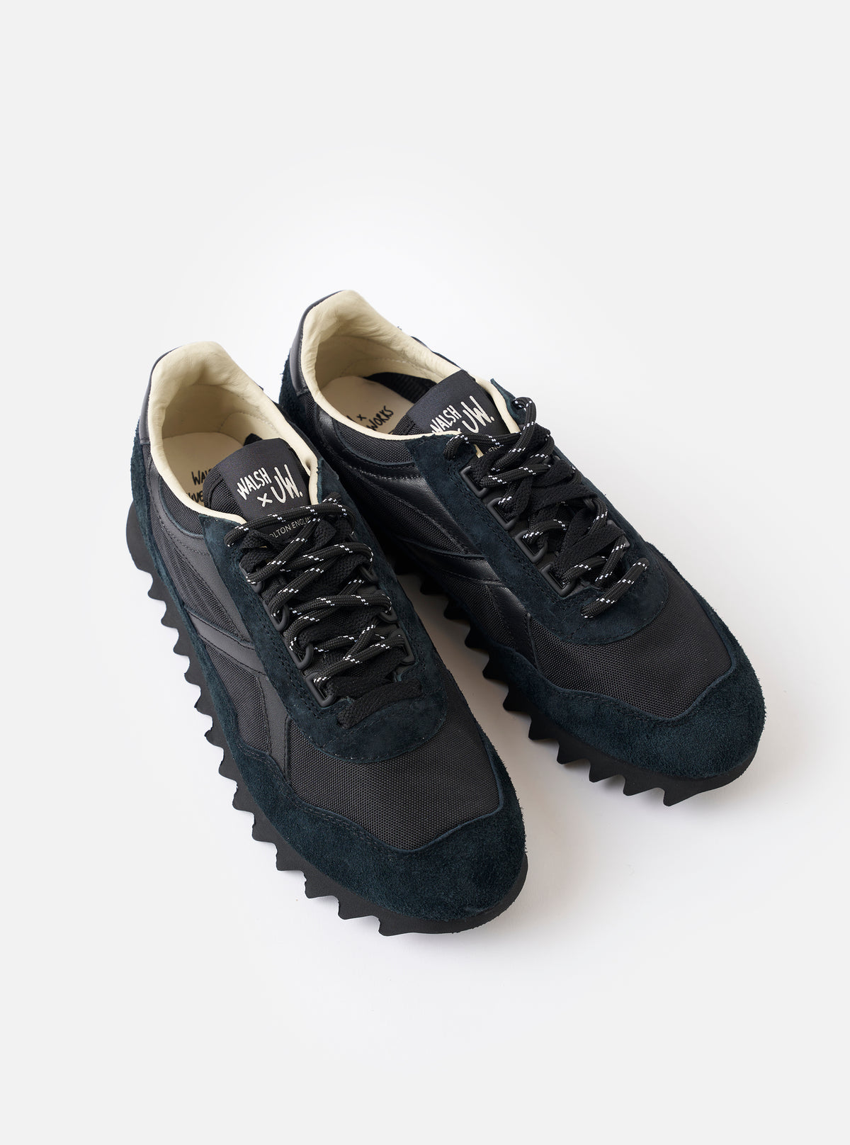 A close-up shot focusing on the back heel tab and collar of the Walsh x Universal Works Ensign in Black Leather/Canvas on a plain white background, showing refined stitching and leather texture.
