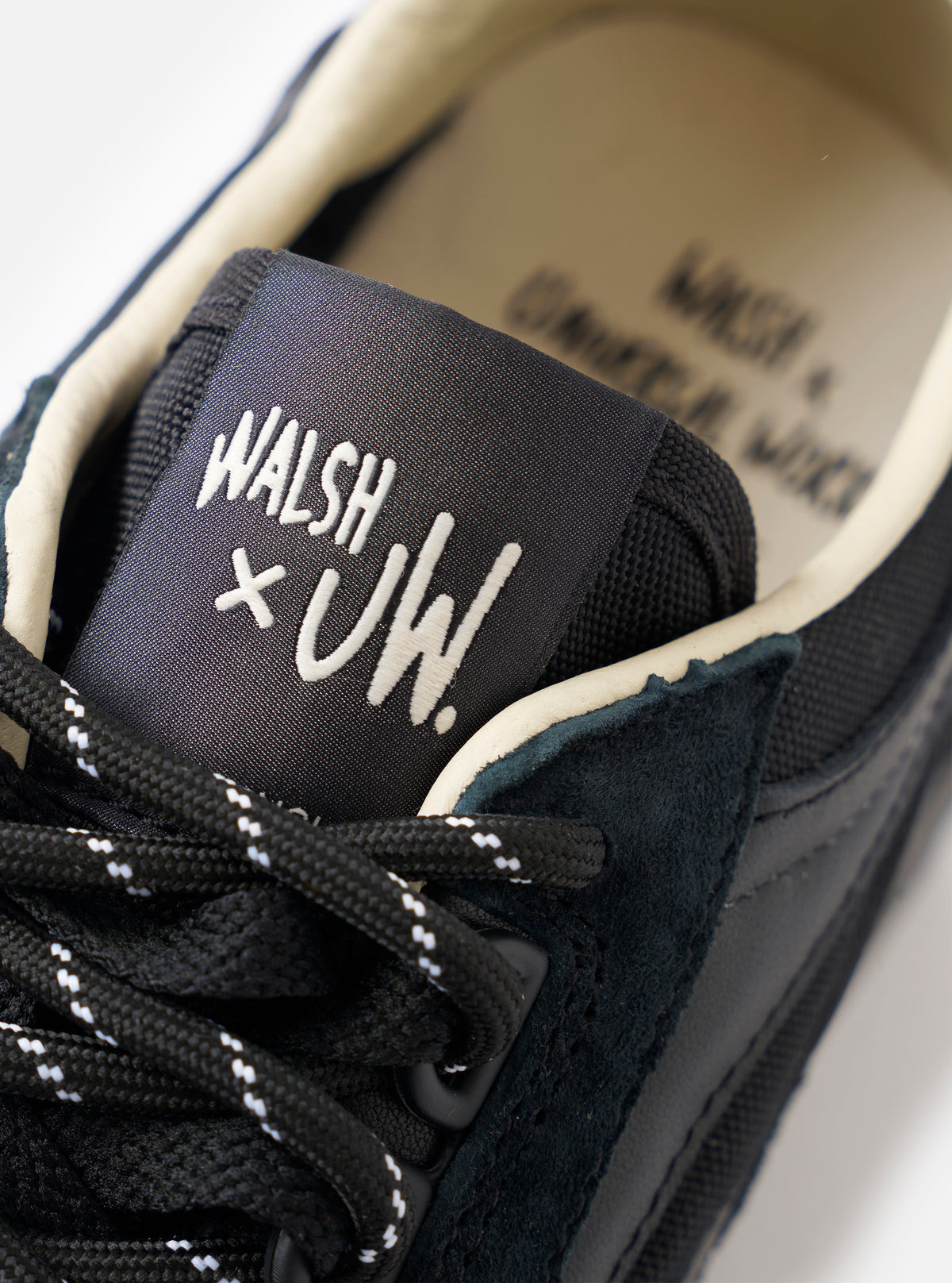 A detailed shot of the toe box on the Walsh x Universal Works Ensign in Black Leather/Canvas set against a white background, emphasizing the durable canvas vamp and supportive leather overlays.