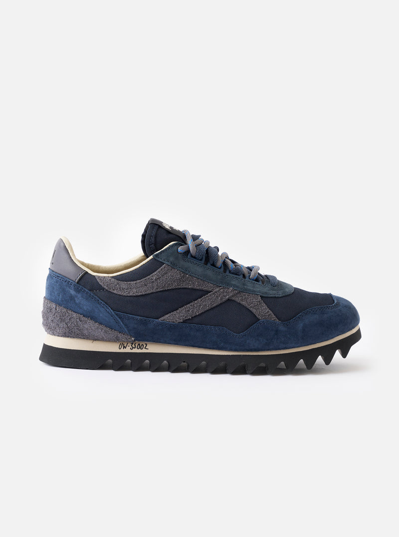 A side profile view of the Walsh x Universal Works Ensign in Navy Leather/Canvas on a clean white background, highlighting the deep navy leather panels, canvas upper, and contrasting midsole.