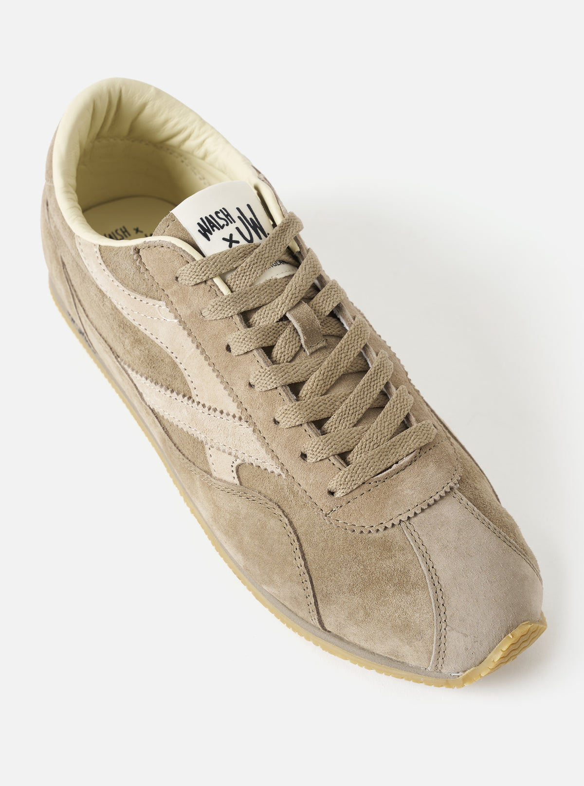 Side profile view of the Walsh x Universal Works Cob in Camel Leather set against a minimalist studio background, detailing the clean panelling, subtle branded tongue tag, lace structure, and low-profile sole.