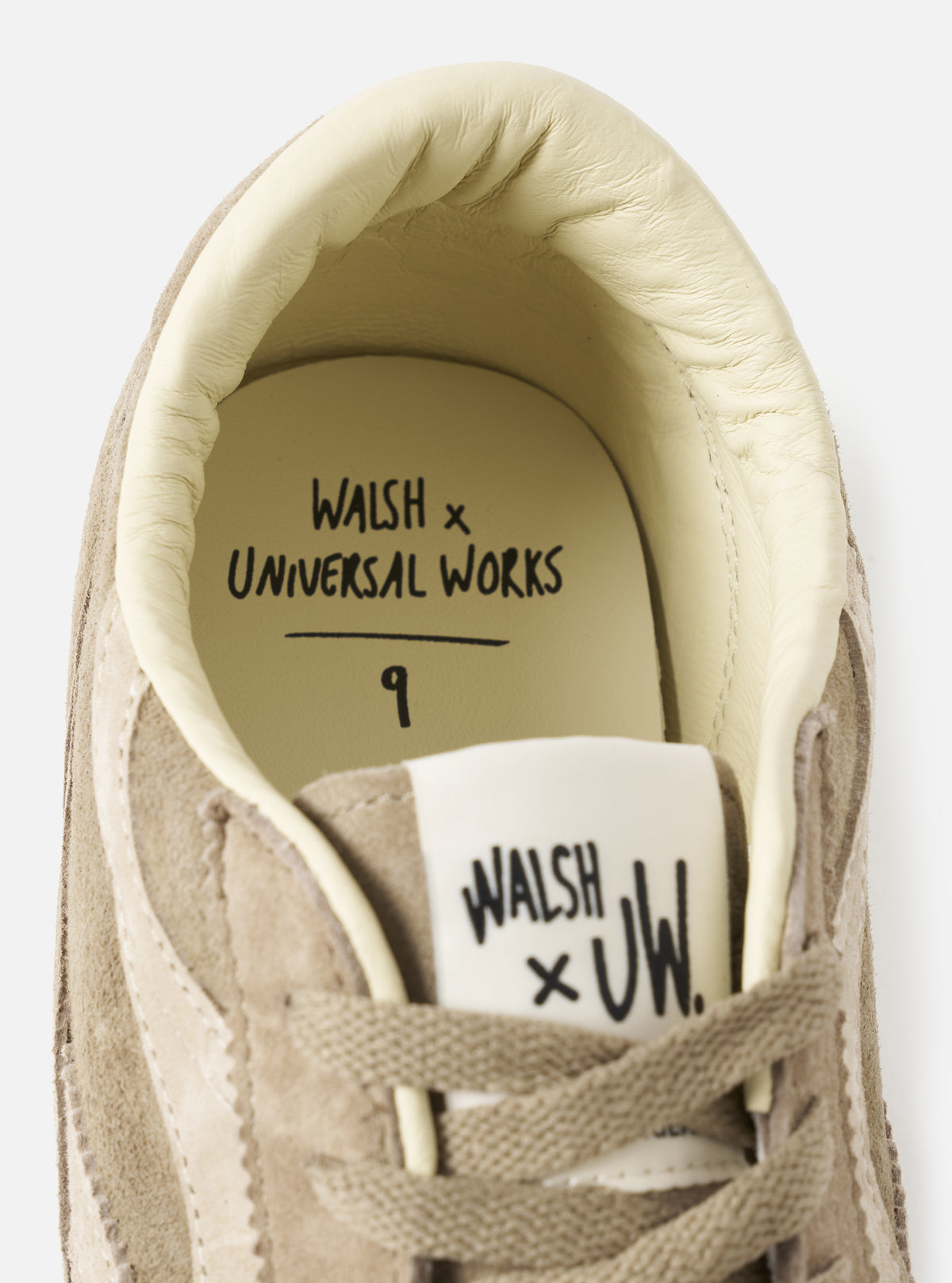 Close-up shot of the Walsh x Universal Works Cob in Camel Leather, highlighting the fine texture of the camel leather, precise edge stitching, and side panel joinery set against a neutral studio backdrop.