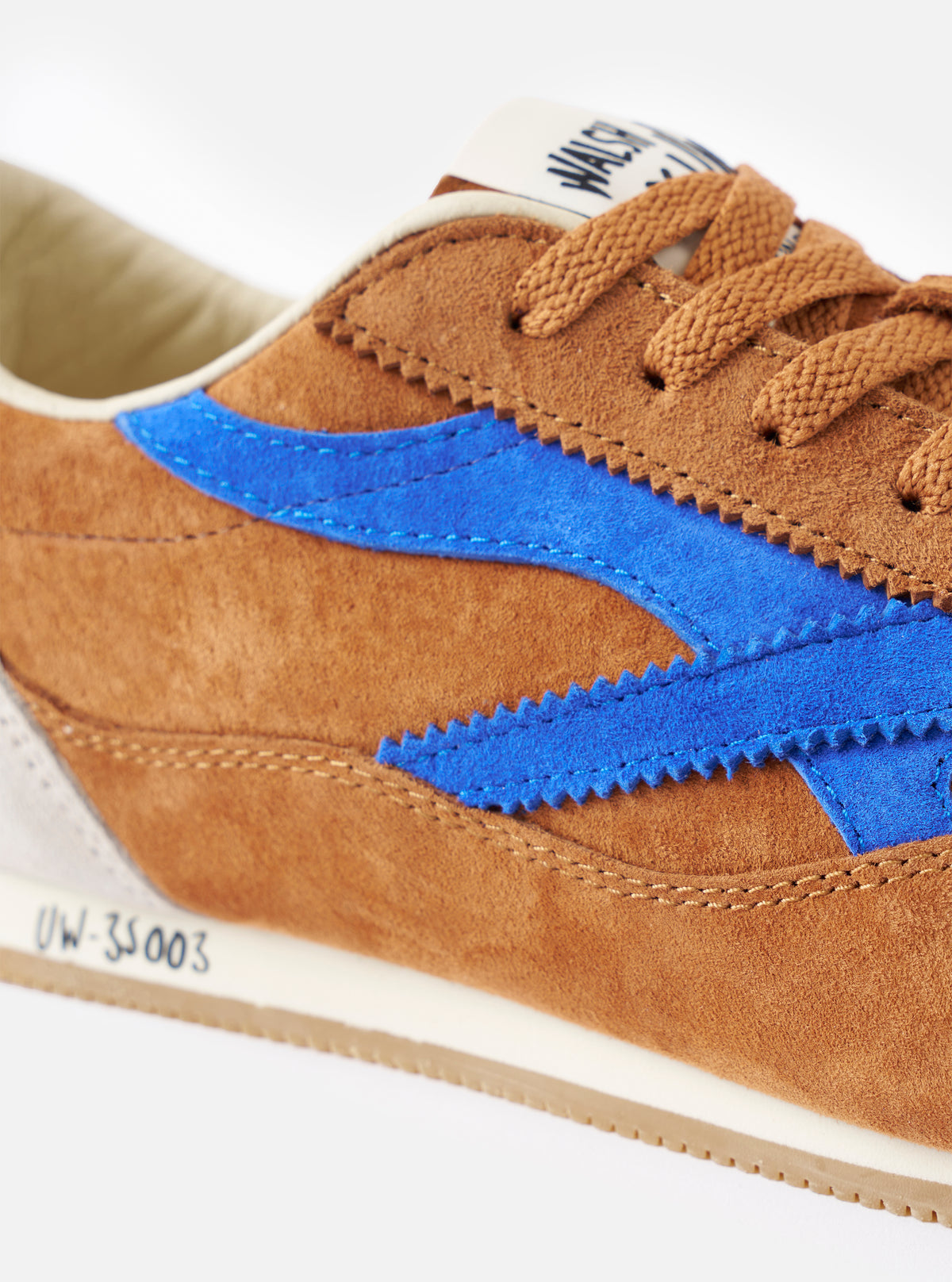Three-quarter angle view of the Walsh x Universal Works Cob in Tan Leather on a light backdrop, emphasizing the smooth leather toe cap, tonal stitching details, and brown leather collar construction.