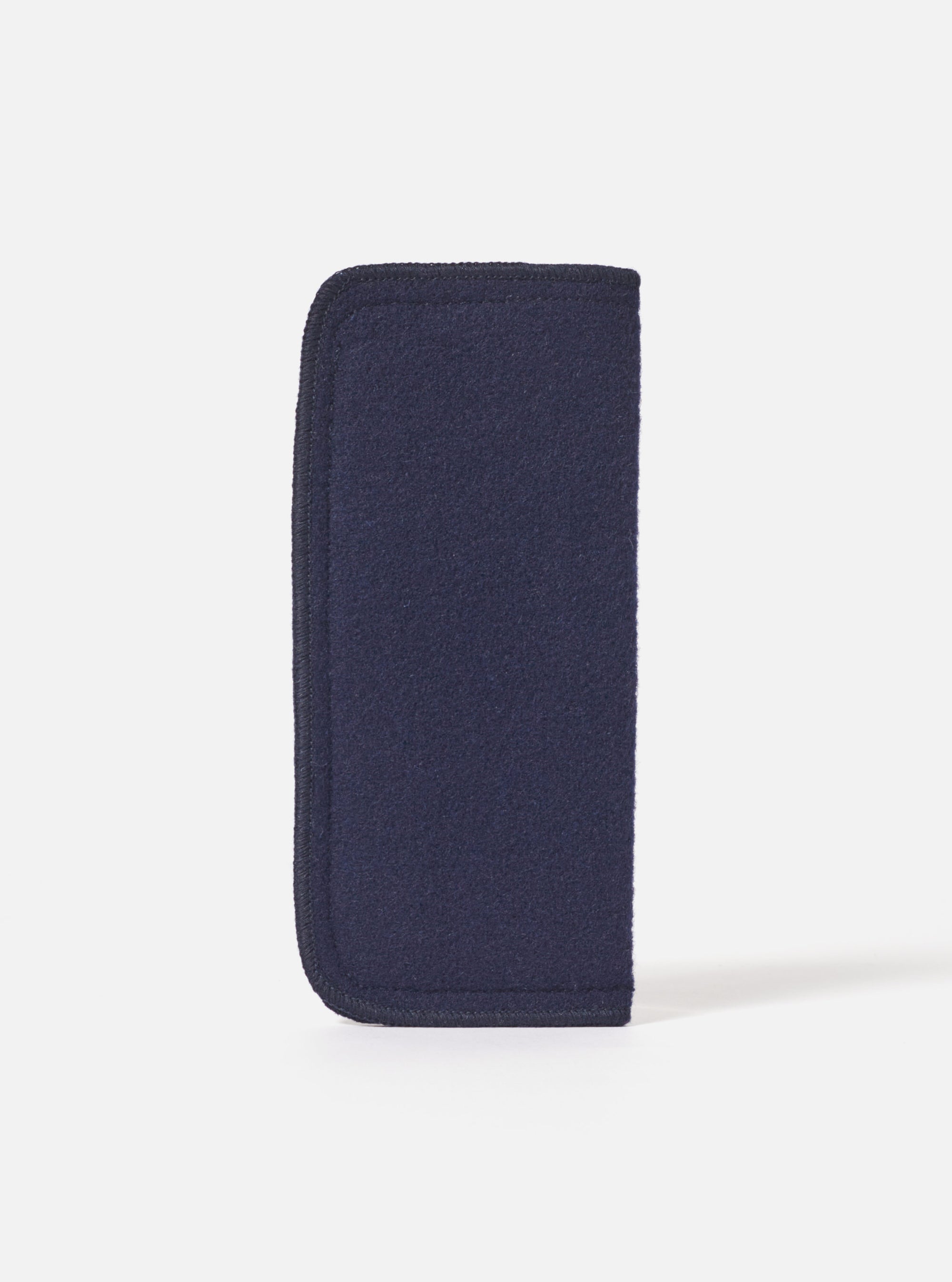Close-up of the Navy Melton Large Glasses Case on a white surface. The case is made of navy blue melton fabric with a dark trim.