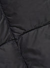 Close-up of the TAION x Universal Works Reversible Black Military Line Vest, showcasing the quilted pattern and material. The vest is laid flat, highlighting the texture.