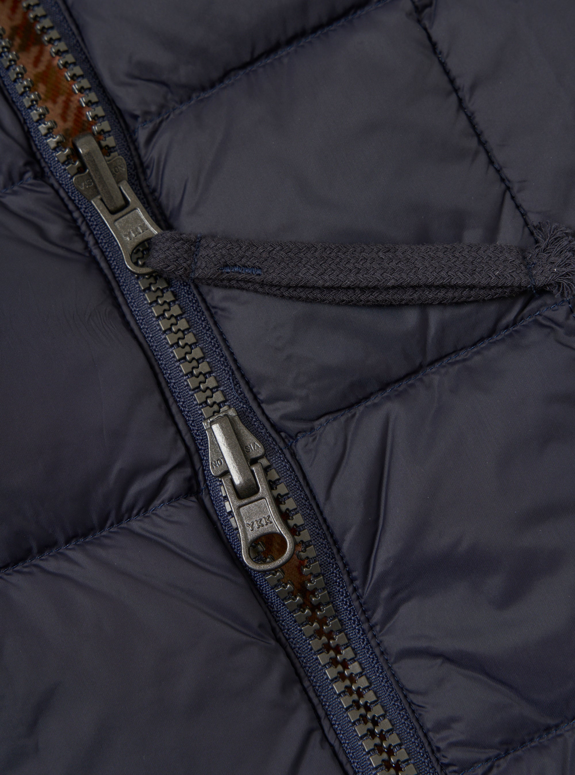 Close up of the TAION x Universal Works Reversible Dark Navy Military Line Vest. Shows the zipper and quilted material. 