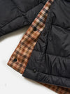 Close-up of the TAION x Universal Works Reversible Black Military Line Liner Jacket. Features black quilted nylon on one side and a brown houndstooth pattern on the other. Shot on a white background.