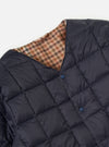 Close-up of the TAION x Universal Works Reversible Dark Navy Military Line Liner Jacket, showing the dark navy quilted material and the reversible houndstooth pattern on a white background.