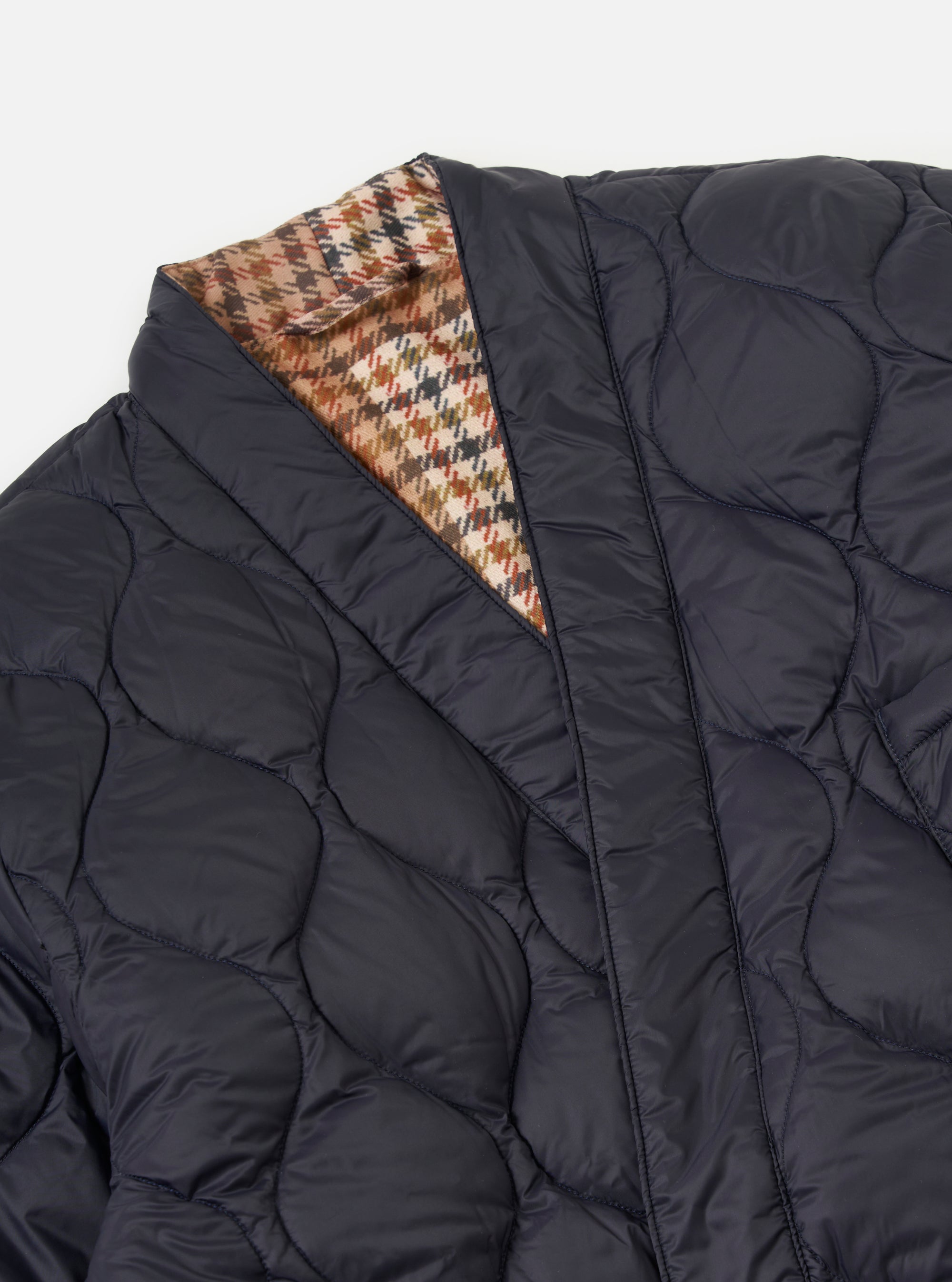 Close-up of the TAION x Universal Works Reversible Dark Navy Military Line Kyoto Work Jacket on a white background. Shows the dark navy quilted material and the brown houndstooth reversible side.