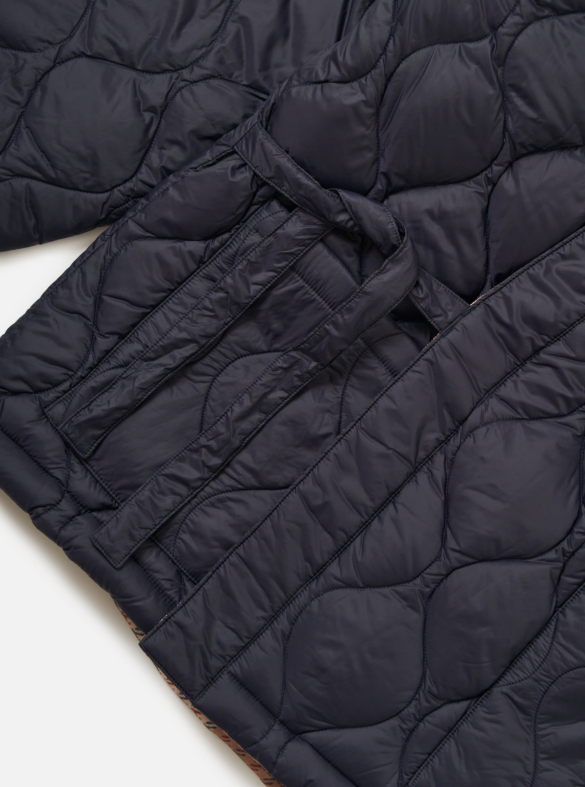 Close-up of the TAION x Universal Works Reversible Dark Navy Military Line Kyoto Work Jacket, showcasing its quilted texture and dark navy color on a white background.