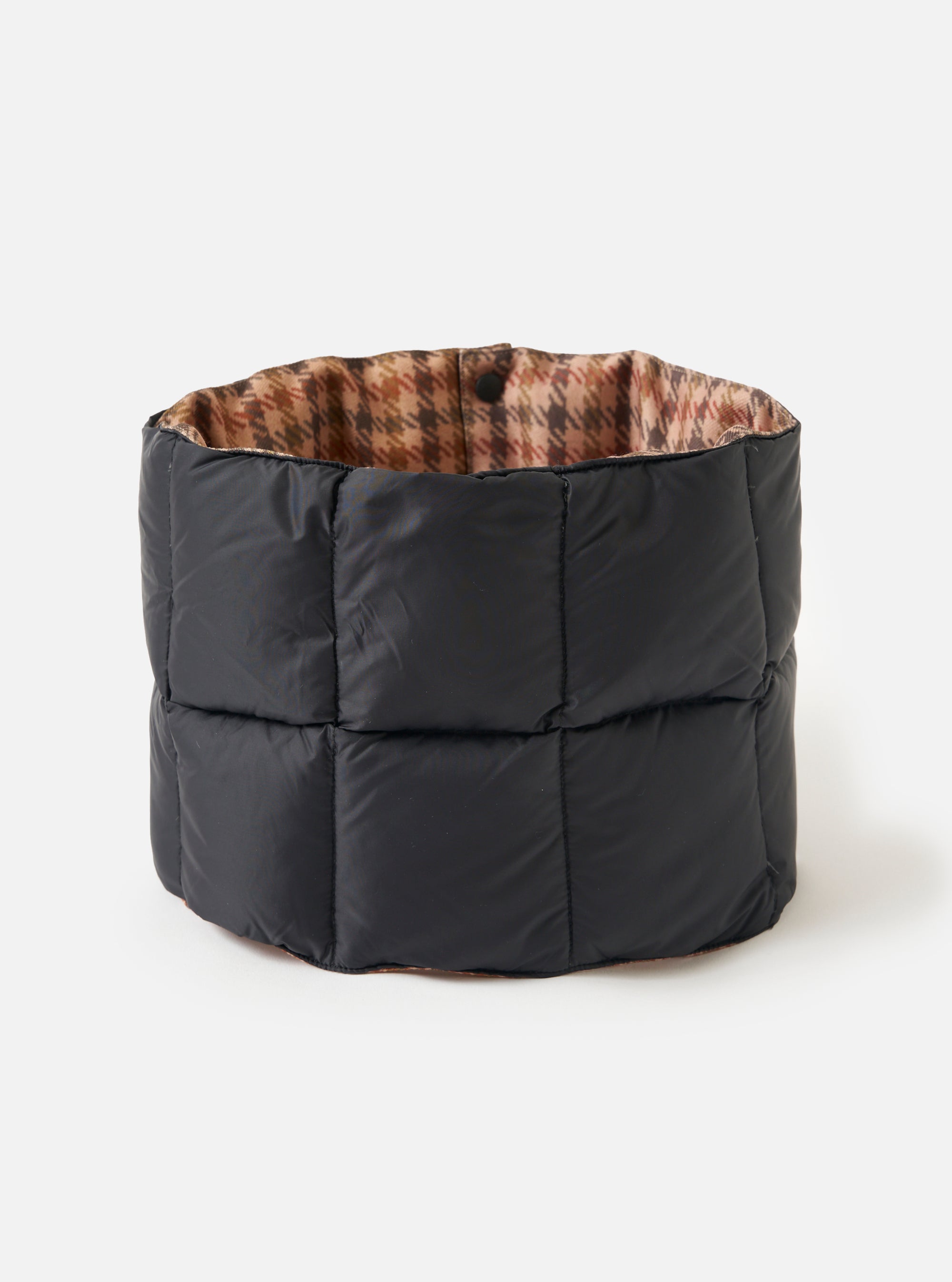 The TAION x Universal Works Reversible Black Military Line Neck Warmer. It's black quilted on the outside and brown houndstooth patterned on the inside. Shot on a white background.