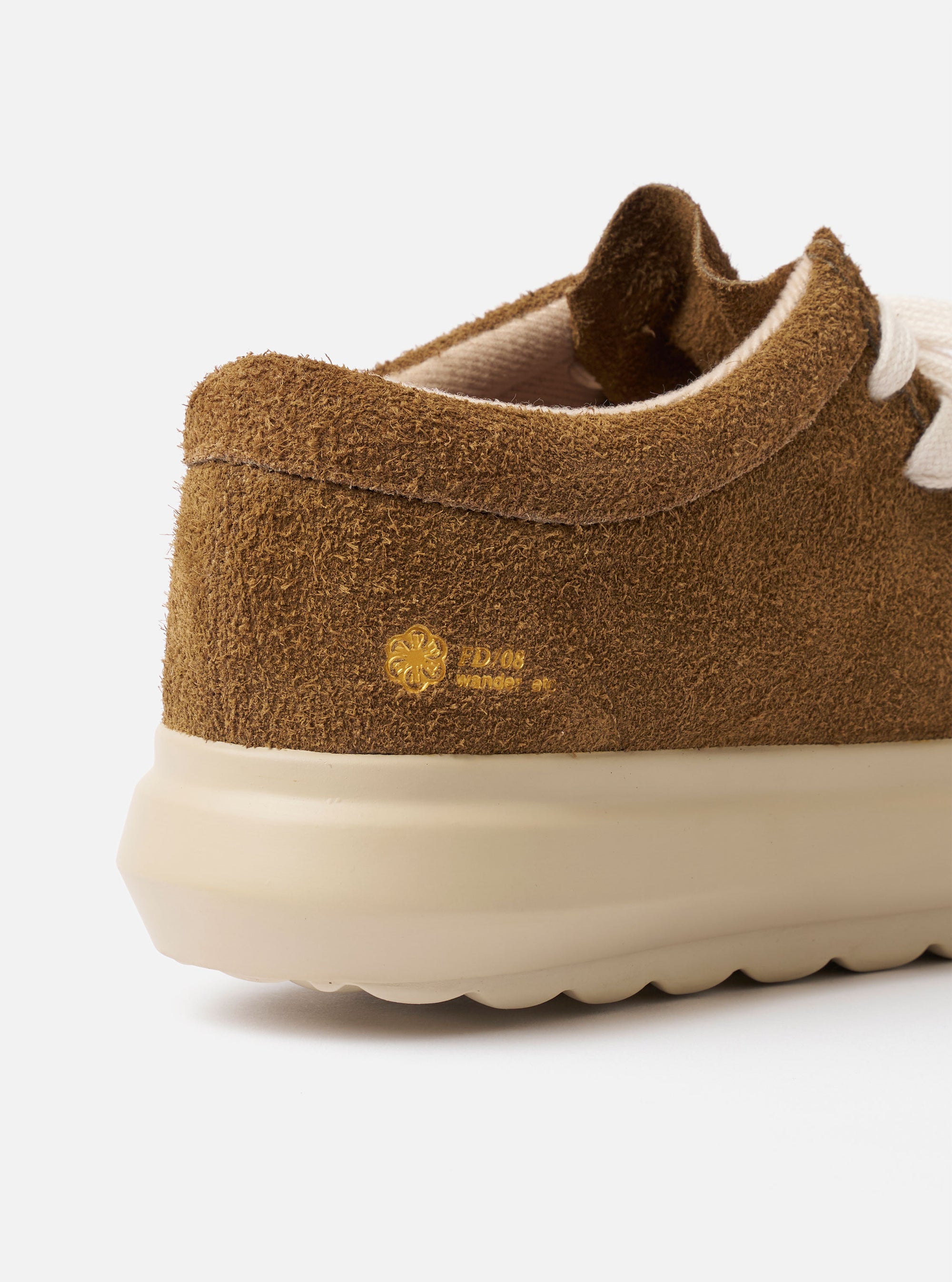 The Wander etc. FD/08 in Tobacco/Off White Suede/Leather is shown from a rear angle as a flat lay against a plain white background. The image highlights the tobacco-colored hairy suede heel counter, the chunky off-white phylon and rubber outsole, and the low-cut silhouette of the shoe.
