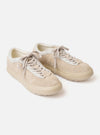 The Wander etc. 'The 70's' in Bone Hairy Suede/Leather is shown from a rear three-quarter angle as a flat lay against a plain white background. The image highlights the shoe's bone-colored hairy suede upper, tonal stitching, and a signature chunky off-white sole. A small black brand tab is visible on the side.