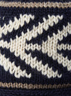 Side angle view of the cableami® Navy Wool Jacquard Watch Cap against a clean studio background, showing the fitted crown, textured wool knit weave, and dark navy tones of the beanie cap clearly.