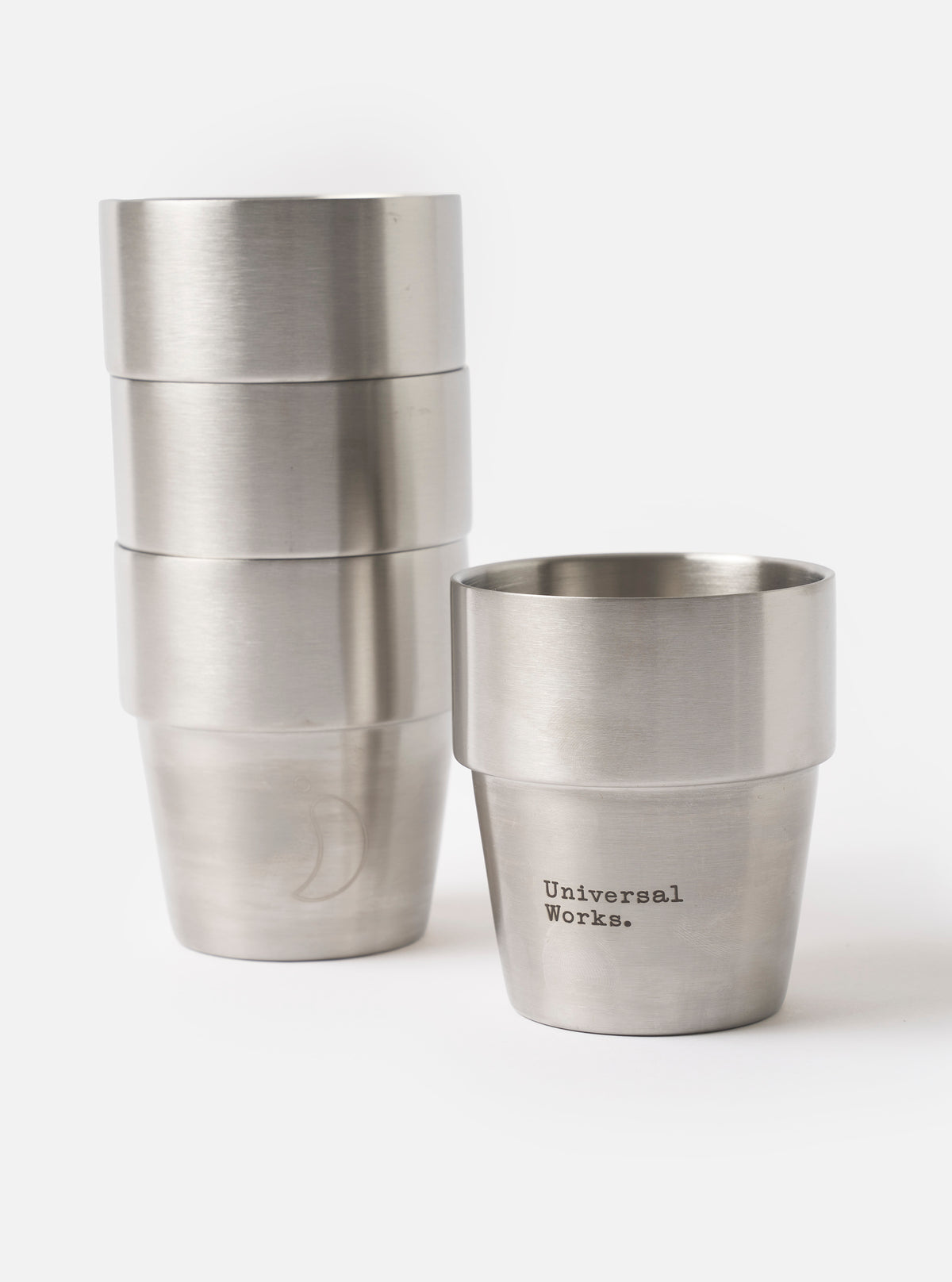 Front view of the Chilly's x Universal Works Set of 4 300ml Stackable Cups arranged side by side on a seamless white backdrop, displaying the dual brand logos printed on the front of each cup.