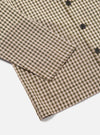 Close-up of the Olive Dobby Check Cancun Jacket on a white surface. Shows the olive, white, and orange check pattern and button details.