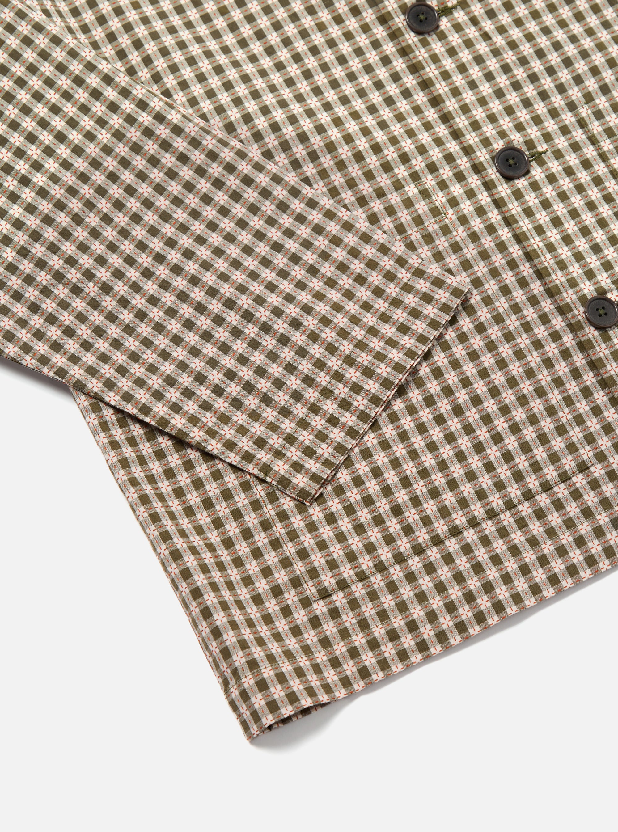 Close-up of the Olive Dobby Check Cancun Jacket on a white surface. Shows the olive, white, and orange check pattern and button details.