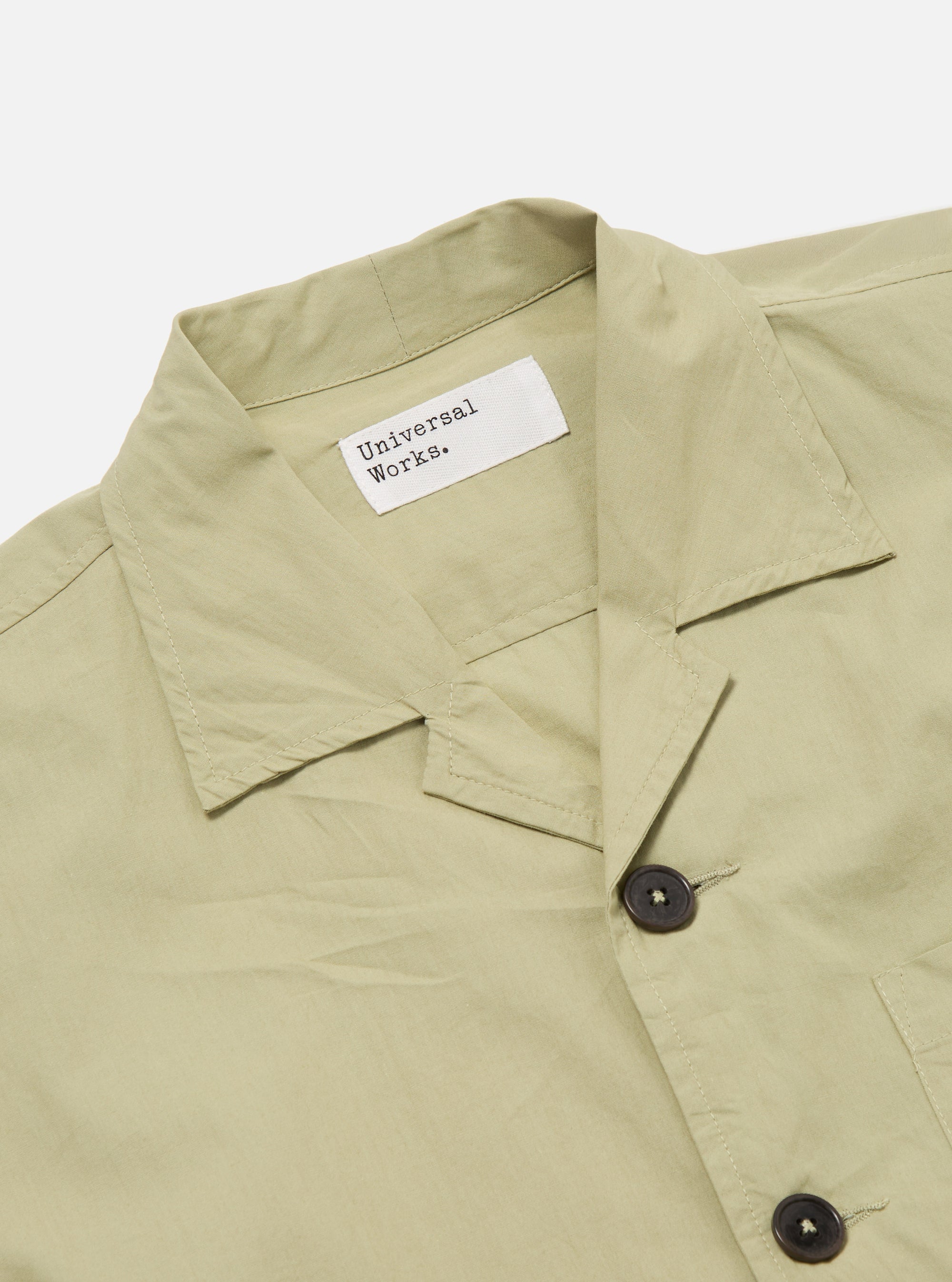 Close-up of the Pale Green Broadcloth Cancun Jacket on a white background. The broadcloth material has a soft, subtle texture. Features a camp collar and button closure.