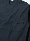 Close-up of the Navy Broadcloth Osaka Work Jacket in navy broadcloth. Features a chest pocket with button closure and blue stitched detailing. Shot on a flat, neutral surface.