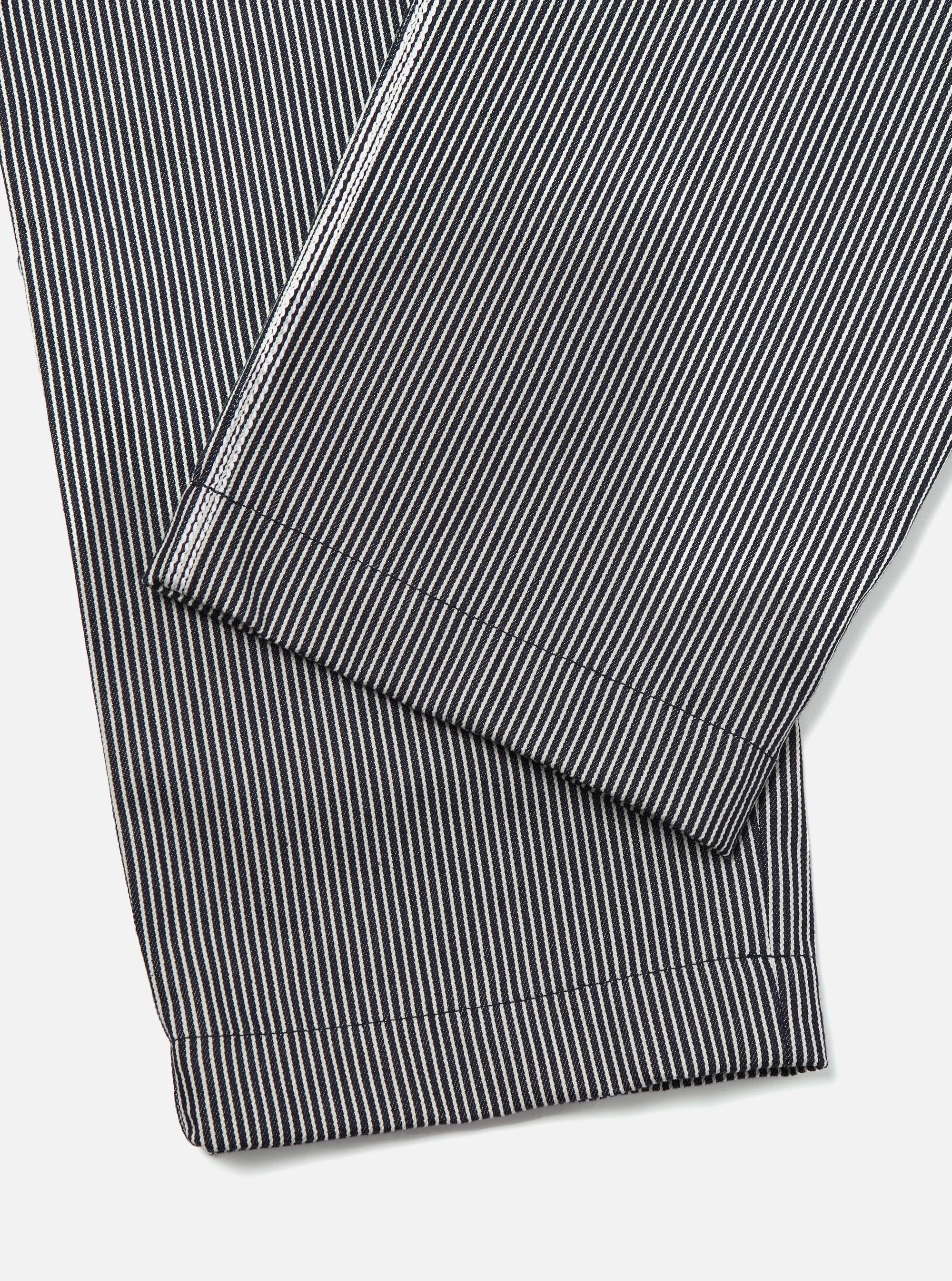 Close-up of the Indigo Hickory Stripe Denim Duke Pant. The denim material features vertical indigo and white stripes. The pants are neatly folded on a white surface.