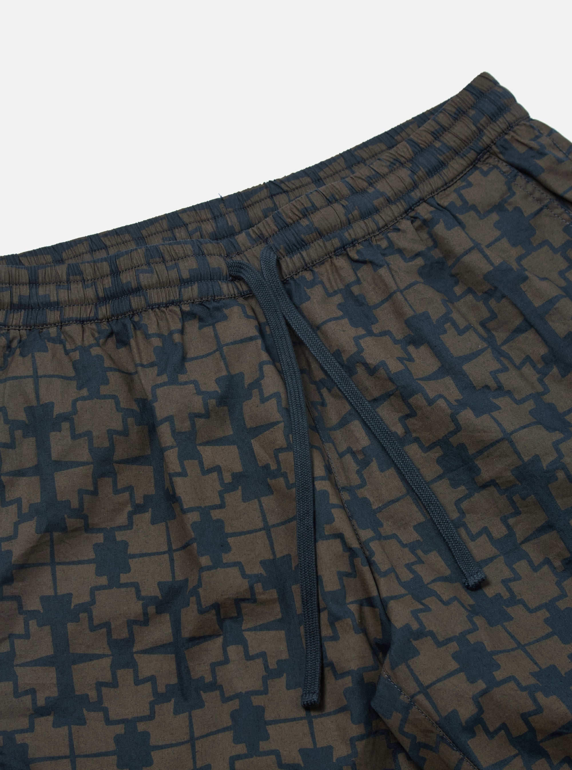 Close-up of the Navy Mitla Print Cotton Simple Short on a white background. The shorts have a navy and brown geometric pattern and a drawstring waist.