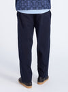 Back view of a model wearing the Navy Military Cotton Judo Pant. The pants are a loose fit and made of cotton. The background is a clean white studio.
