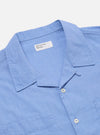 Close-up of the Blue End On End Cotton Garage Shirt on a white surface. The light blue cotton shirt has a collar, buttons, and chest pockets.
